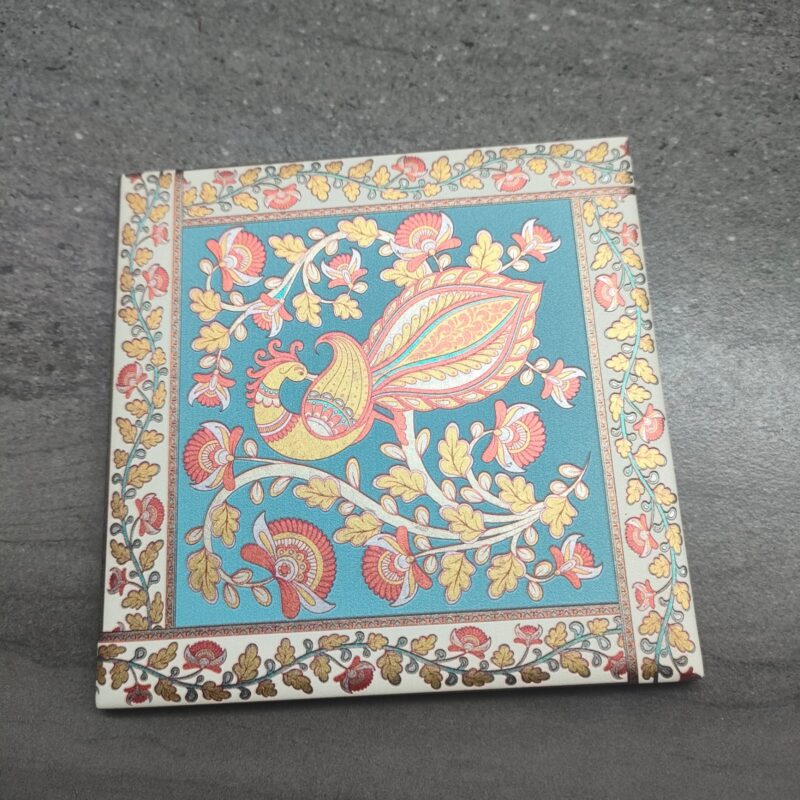 Square ceramic tile with Kalamkari peacock design.