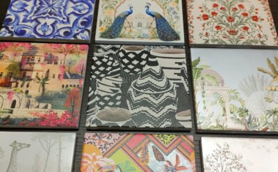 A collection of ceramic tiles with various artistic designs, including floral patterns, peacocks, architectural motifs, and geometric shapes.
