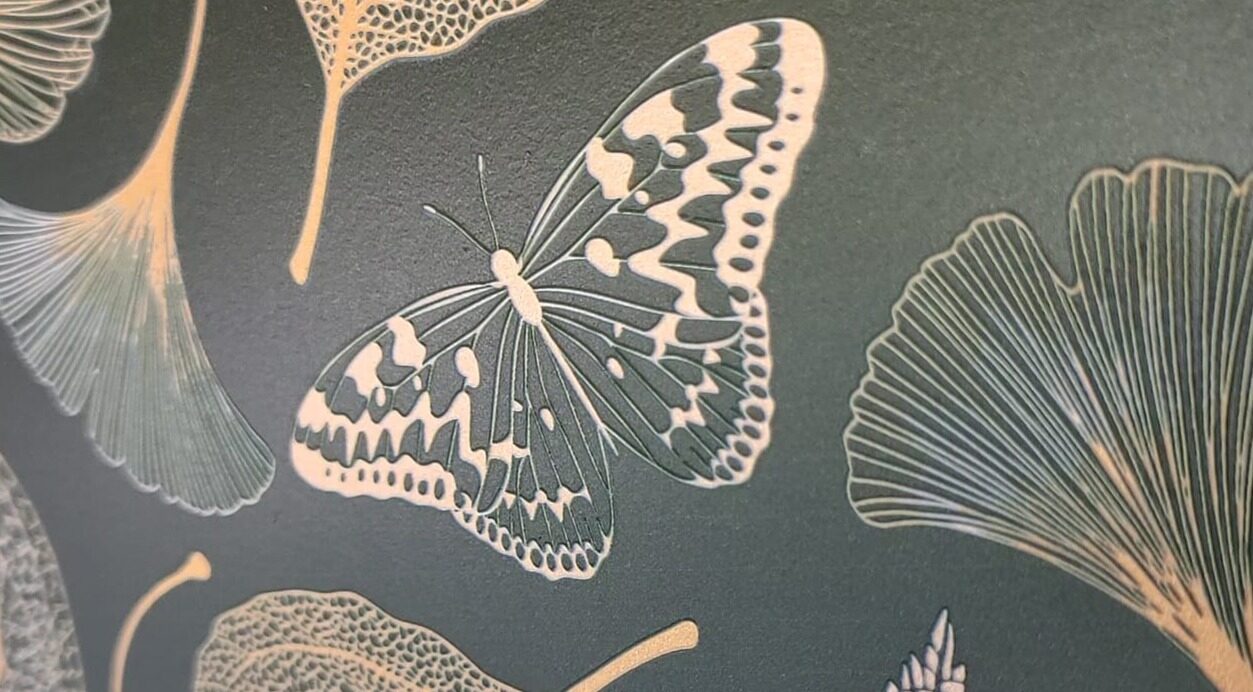 Textured ceramic tile with embossed butterfly and ginkgo leaf design.