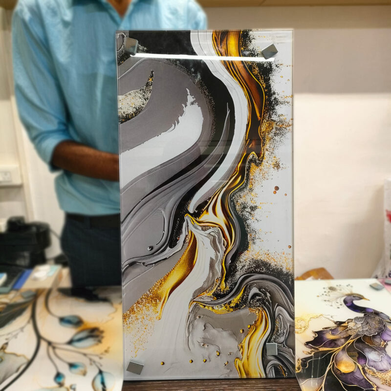 Contemporary abstract art featuring swirling grey and gold patterns, printed directly on glass.