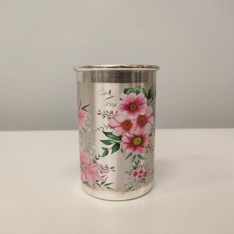 A silver glass with a floral design printed on it.