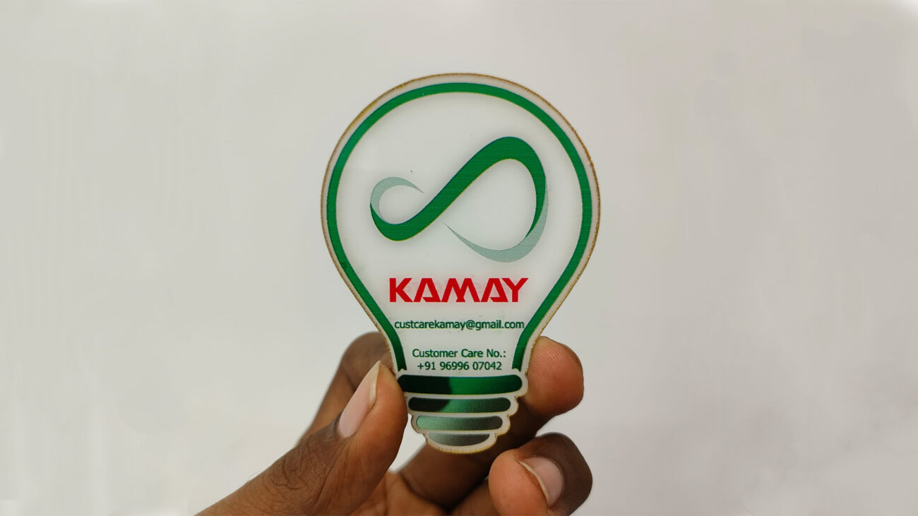 A unique business card shaped like a light bulb with the word "KAMAY," email, and phone number.